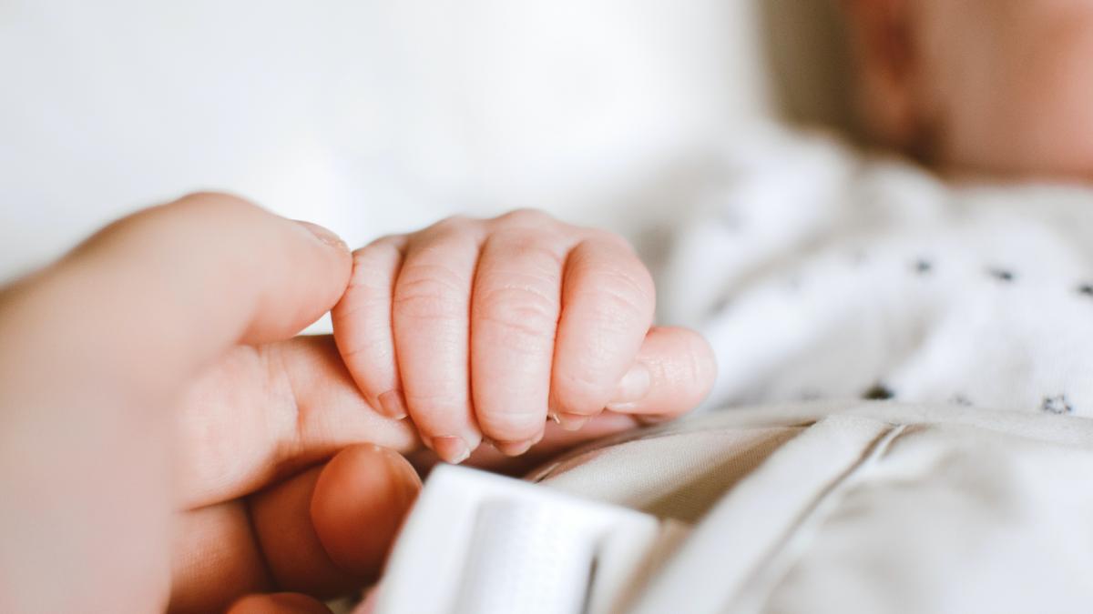 Foto van babyhandje dat volwassen hand vastpakt
