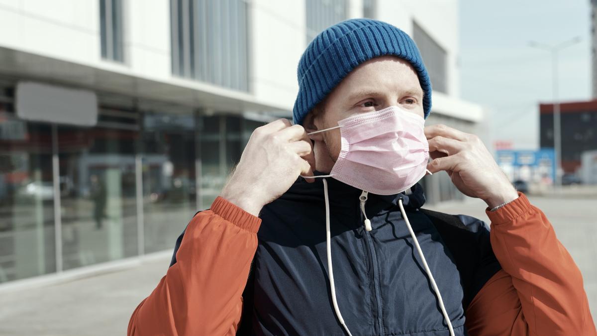 Foto van persoon die mondmasker aandoet
