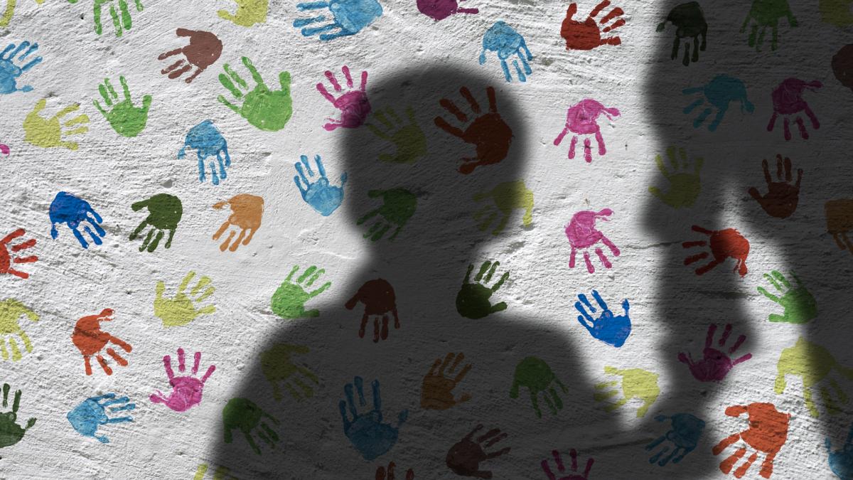 Foto van schaduw kind op witte muur met geverfde kinderhandjes