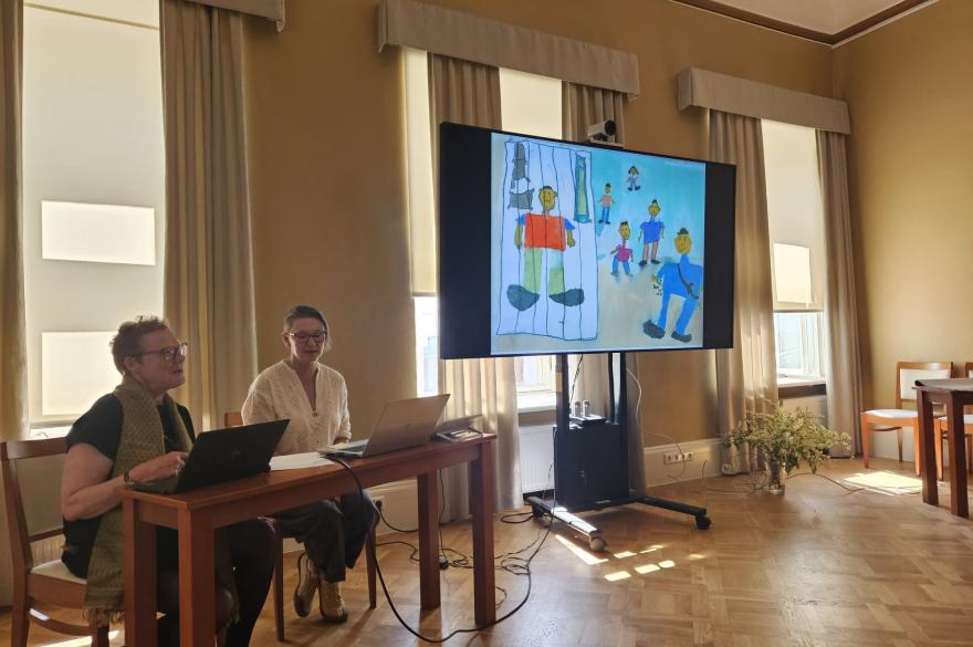 Presentatie op scherm van kindertekening van kinderen waarvan een ouder in de gevangenis verblijft.