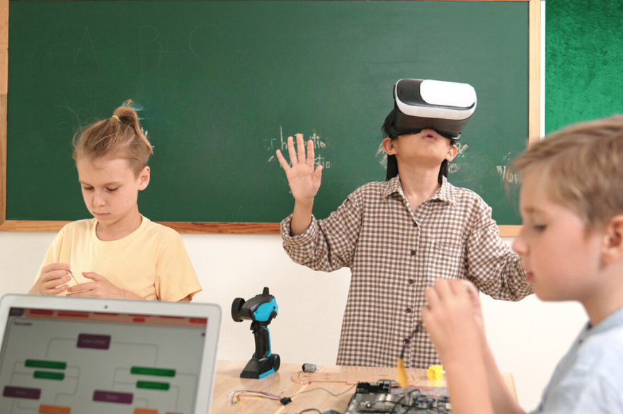 Drie kinderen in de klas 1 kind met een AI-bril op